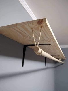 a piece of wood hanging from a ceiling with ropes attached to the top of it