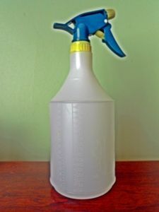 a white jug with a blue sprayer on top