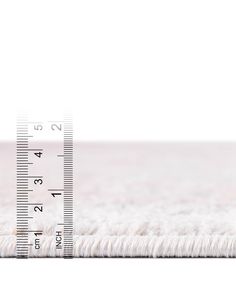 a white rug with a measuring tape on it