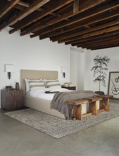 a large bed sitting under a wooden beam in a bedroom