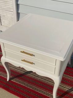 a white table sitting on top of a red rug