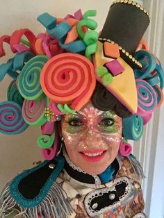 a woman with colorful hair and make up on her face wearing a costume made out of candy