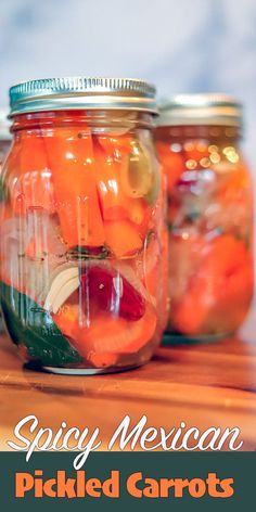 jars filled with pickled carrots sitting on top of a wooden table