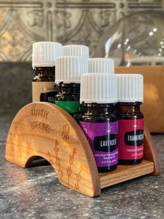 bottles of essential oils sit on a wooden stand