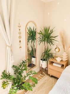 a bedroom with plants and a mirror on the wall