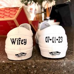 two white shoes with black writing on them sitting on top of a granite countertop