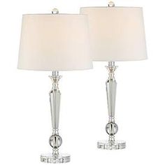 pair of crystal table lamps with white linen shades on each lamp and chrome finish base