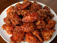 a white plate topped with fried food on top of a wooden table