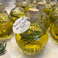 several olive oil bottles with rosemary sprigs in them