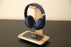 an iphone and headphones on a wooden stand