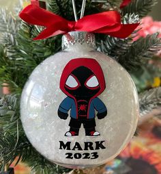 a spider man ornament hanging from a christmas tree