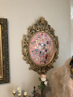 there is a gold framed painting on the wall next to a fur coat and vases