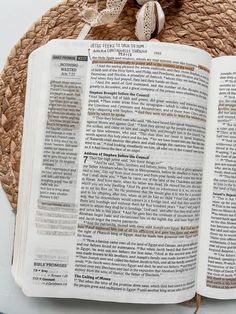 an open bible laying on top of a woven mat