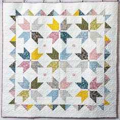 a quilted wall hanging with an arrow pattern on it