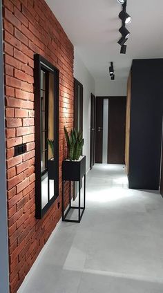 an empty hallway with brick walls and plants