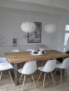 a dining room table with white chairs around it