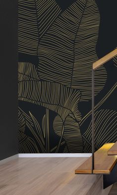 an artistic wallpaper design with gold leaves on a black background is the focal point for this stair case