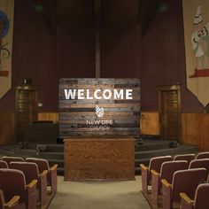 a welcome sign is displayed in front of an empty auditorium