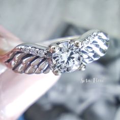 a close up of a person holding a diamond ring