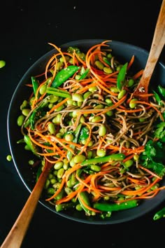 a bowl filled with carrots, peas and sprouts