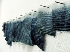 several pieces of fabric hanging on a wall