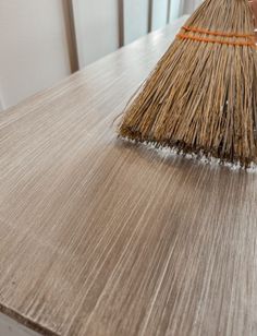 a broom sitting on top of a wooden table