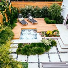 an outdoor hot tub surrounded by greenery and decking with lounge chairs on it