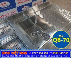 a stainless steel sink with two faucets on the side and a blue sign that says nox viet nam