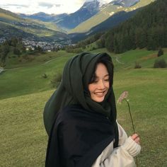 a woman wearing a hijab and holding a flower