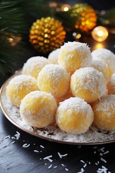 a plate filled with snowball cookies on top of a table next to christmas decorations