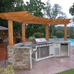 an outdoor kitchen next to a swimming pool and covered patio with pergolated roof