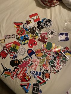 a bed covered in lots of stickers on it's side next to a pillow