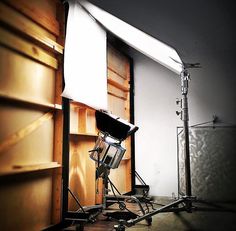 an empty photo studio with lighting equipment in the foreground and wood paneled walls