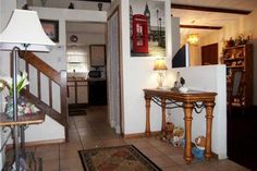 an entry way leading to a living room and dining room area with tile flooring