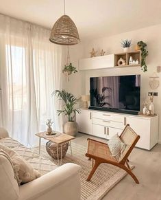 a living room filled with furniture and a flat screen tv on top of a wooden stand