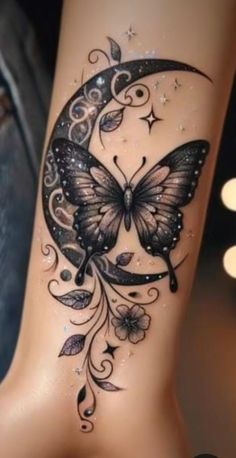 a woman's leg with a butterfly and moon tattoo design on the side of it