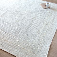 a close up of a white rug on a wooden floor with a pair of scissors