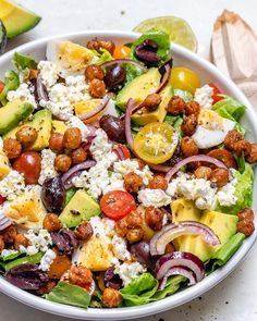 a salad with tomatoes, avocado, chickpeas and feta cheese