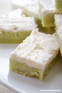 several pieces of green and white cake on a plate with the words pistachio sugar cookie bars