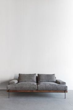 a gray couch sitting in front of a white wall