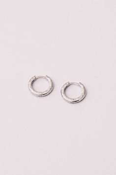 These .925 Silver hammered huggie hoop earrings are an elevated update to your everyday look. 360 degree hoops offer comfortable, chic and effortless flair. Their artisanal quality will take your casual look from blah to sleek chic! Dimensions: 1/2" Materials: .925 Silver Ships in a branded jewelry pouch and box, perfect for gift giving! Care Instructions: Take steps to protect your sterling silver by keeping it in airtight packages, use tarnish-resistant products (such as tarnish tabs or strips Silver Huggie Hoop Earrings, Silver Huggies, Silver Huggie Earrings, Huggie Earrings Silver, Necklace Outfit, Comfortable Chic, Sleek Chic, Jewelry Aesthetic, Pretty Jewelry