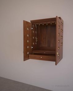 an open wooden box on the wall with brass rivets and screw holes in it