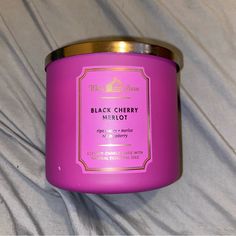 a pink candle sitting on top of a bed