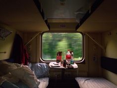 there are two twin beds in this small room with the window open and bottles on the table