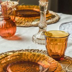 the table is set with orange glass dishes