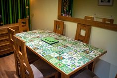 a dining room table with green and white tiles on it