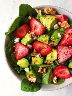 a salad with strawberries, avocado and walnuts