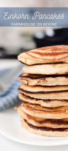 stack of pancakes sitting on top of a white plate next to a blue and white napkin