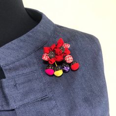 a close up of a person wearing a blue shirt with red and yellow buttons on it