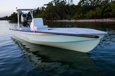 a small white boat floating on top of a body of water